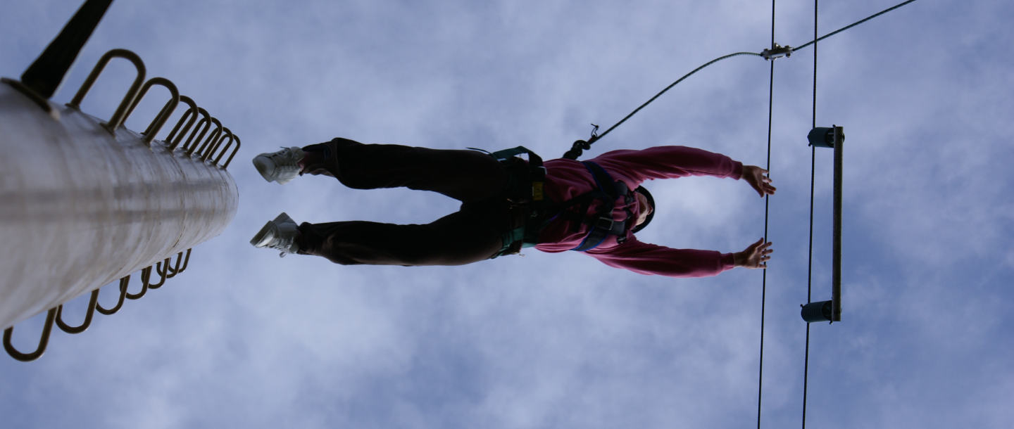 a person jumping from a zip line