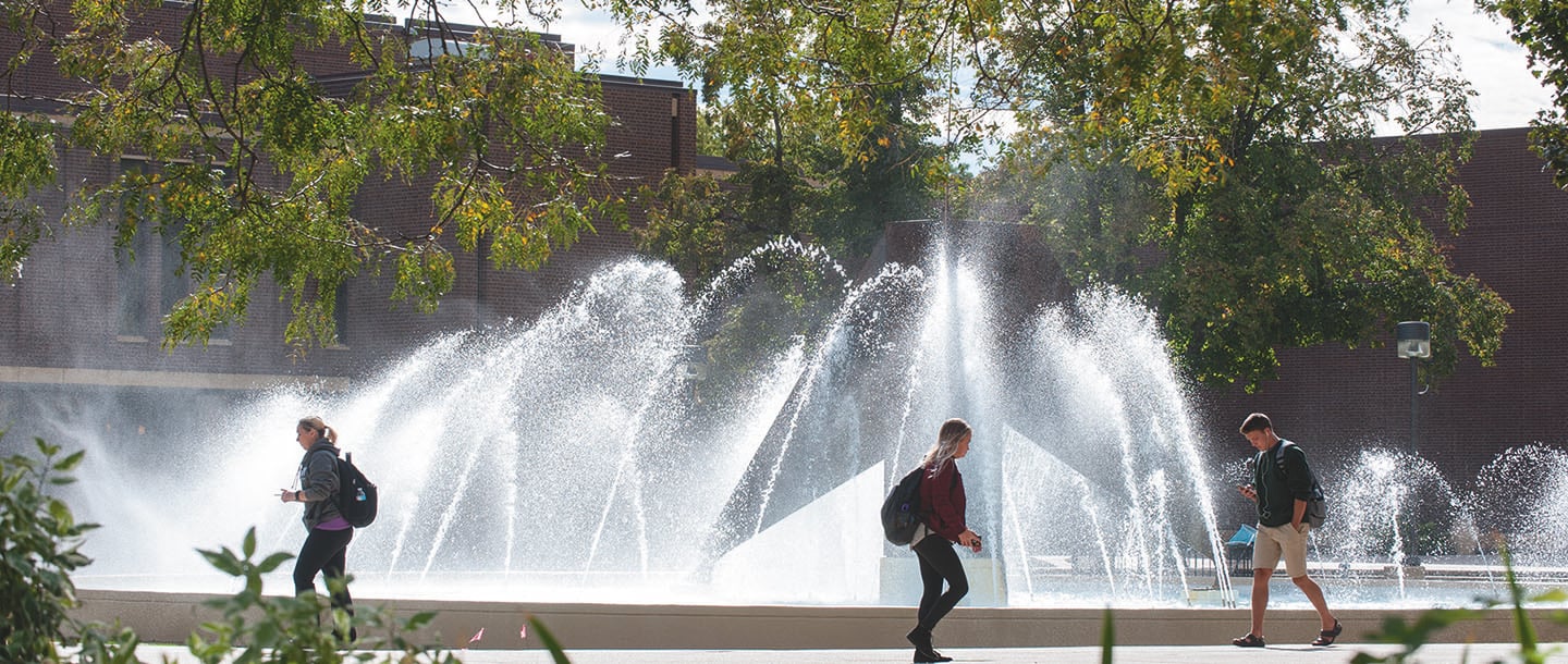 Students walking on campus by the Minnesota State Mankato fountain on a sunny day