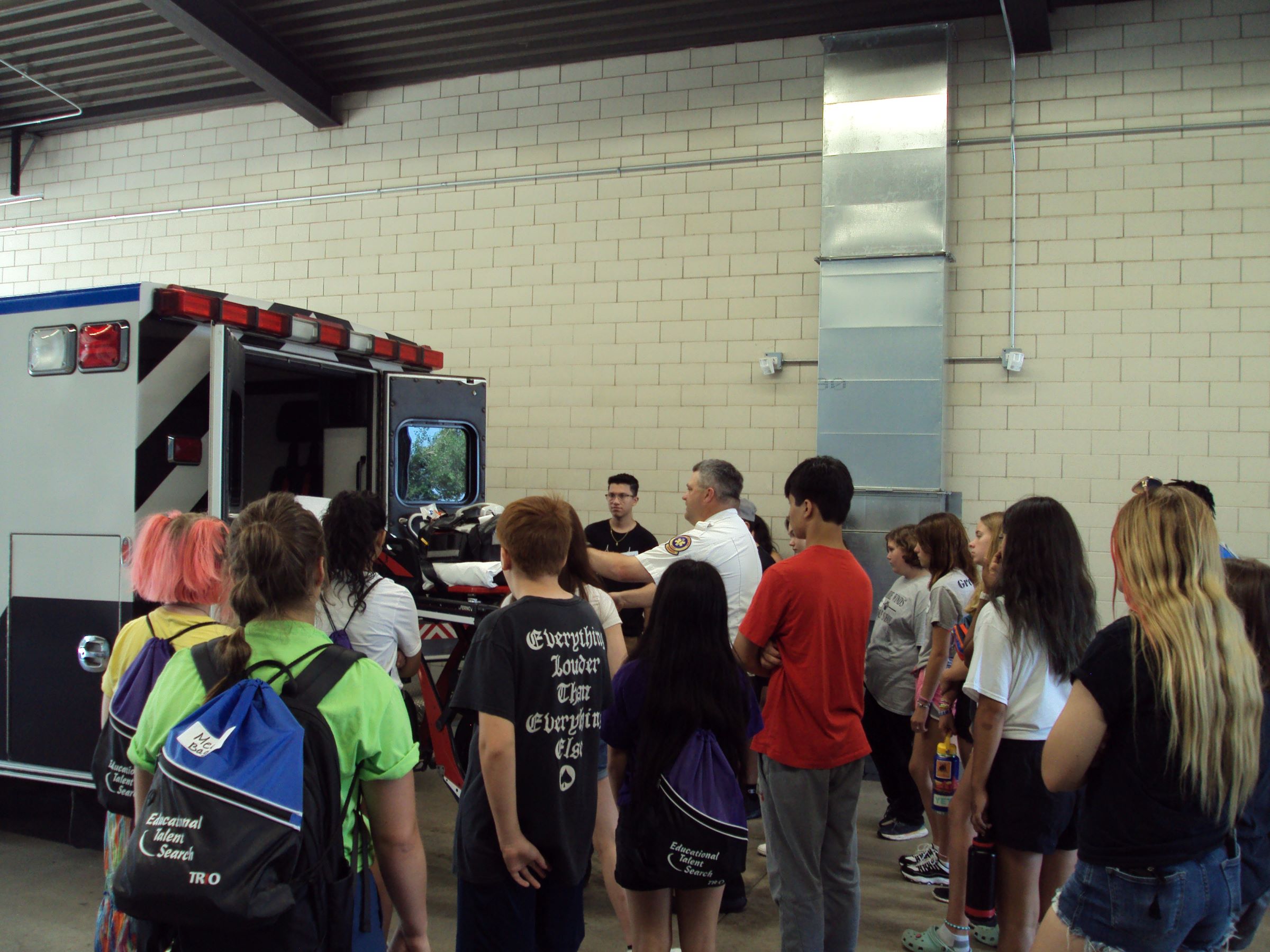 a group of people standing around a ambulance