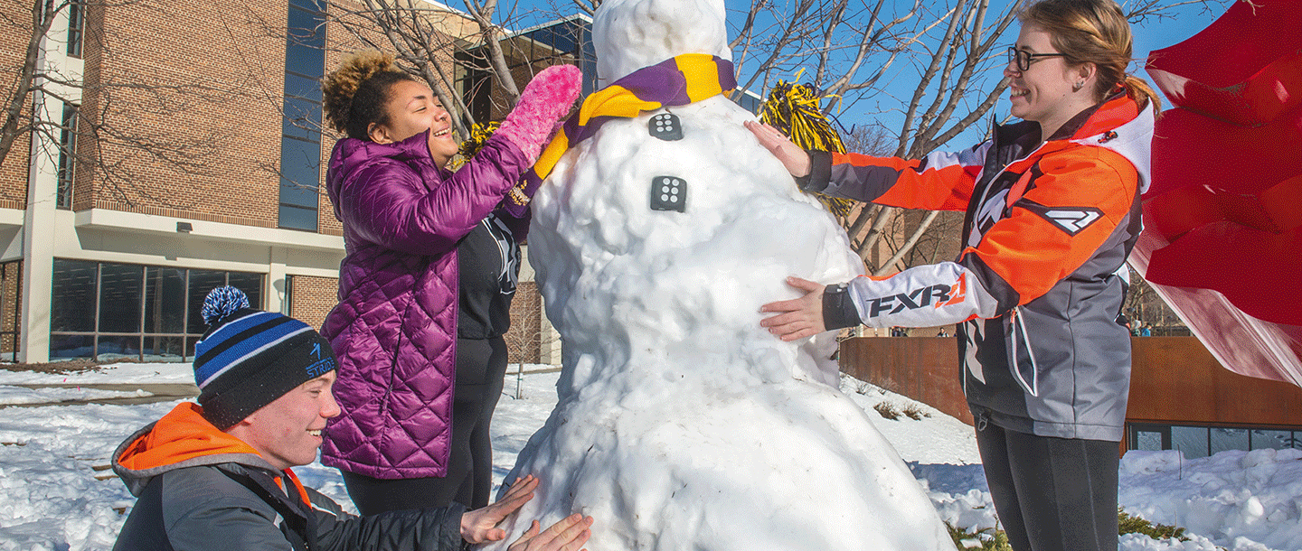 a person standing next to a snowperson