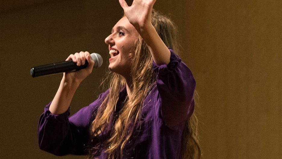 a person with her hand up and a microphone