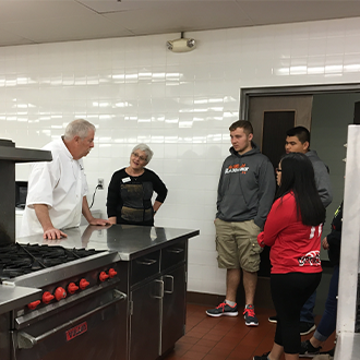 ETS students talking to a chef in the culinary classroom kitchen at HTCC