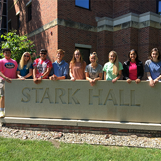 ETS students posing for a picture, at Winona State University, in front of Stark Hall