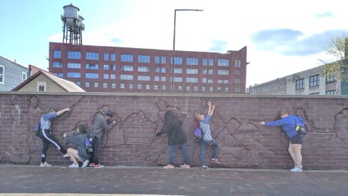 A group of people posing on a wall painting 