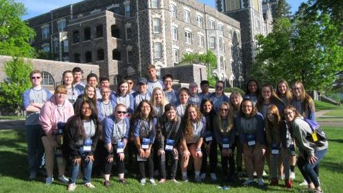 A group of students posing in front of college st. scholastica