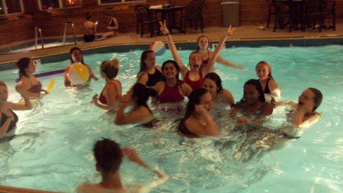 ETS students, having fun, playing a game with a beach ball in a hotel pool