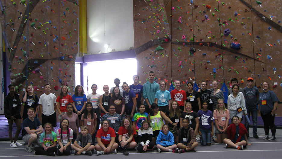 ETS students posing in front of the Minnesota State Mankato indoor rock climbing wall