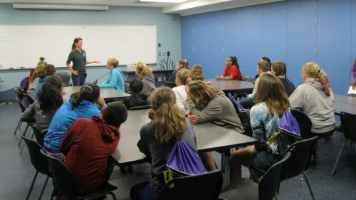 ETS students listening to a presentation, in a classroom, by a staff member at the minnesota zoo
