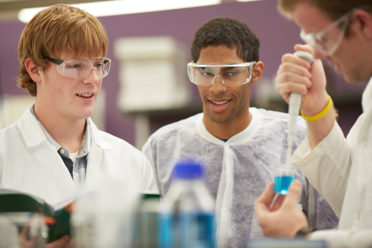a group of young men in lab coats and goggles