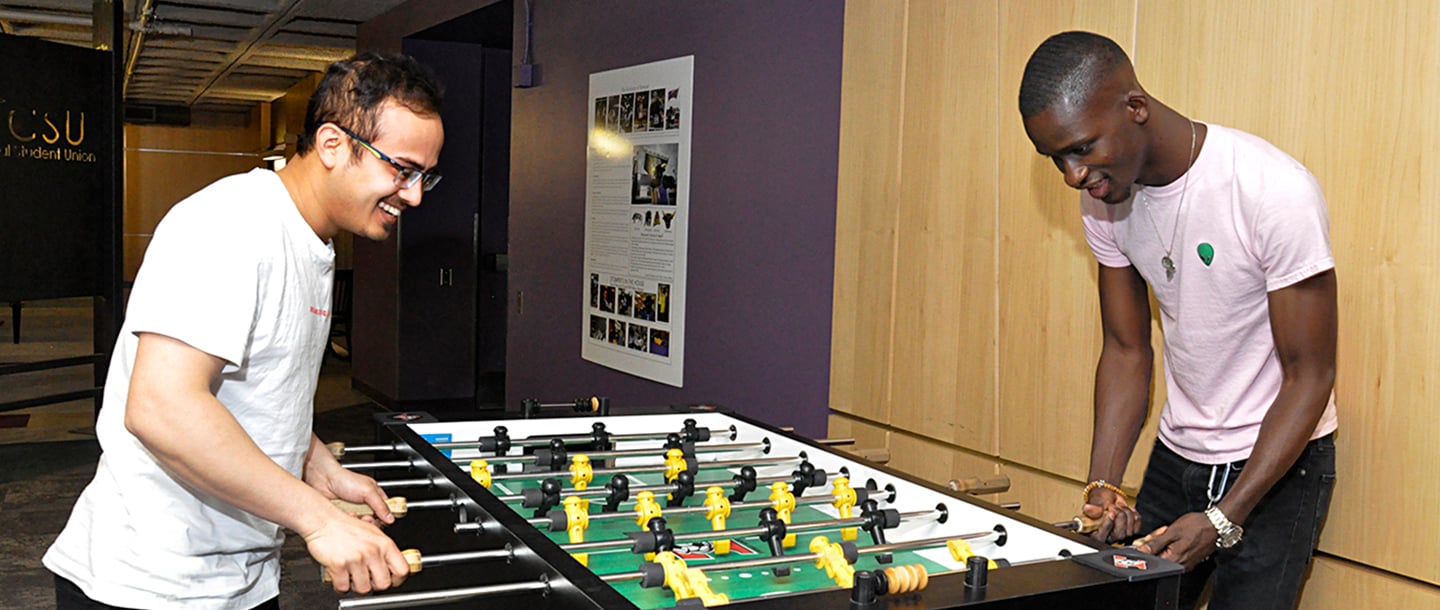 Two students playing Foosball