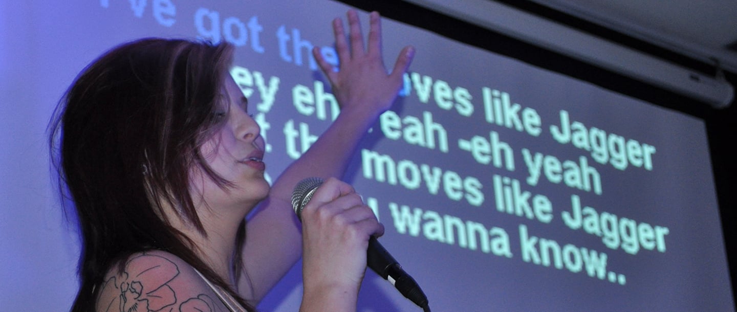 A girl performing karaoke in the bullpen