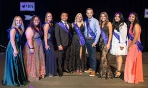 Members of the Homecoming Royalty Court of 2022 posing for a photo on the stage inside campus wearing purple sashes