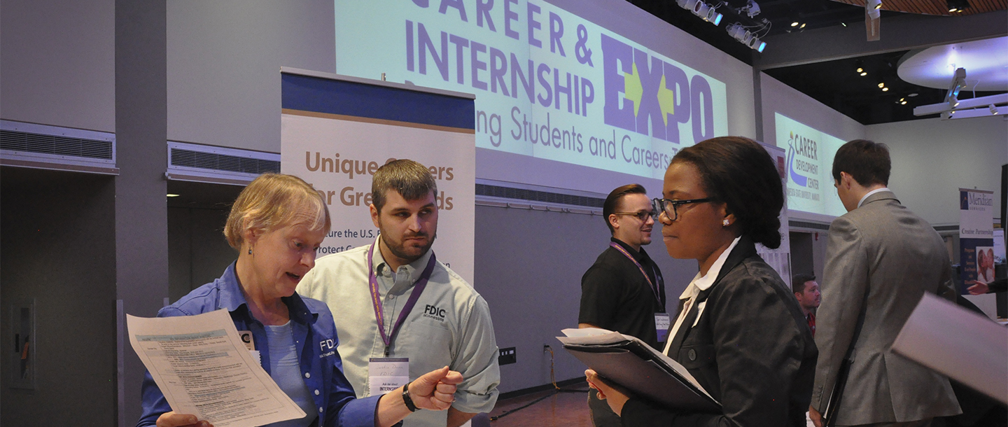 Recuiter talking with a colored student about her resume in the Minnesota State University Career Expo