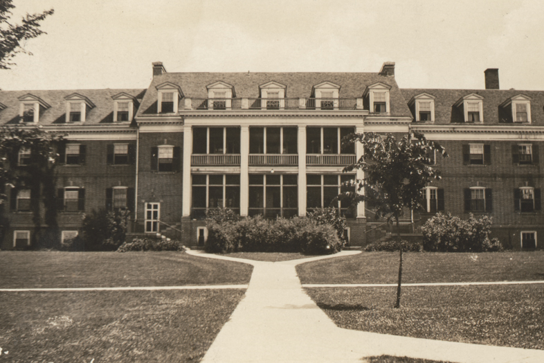 a large brick building with a walkway leading to it