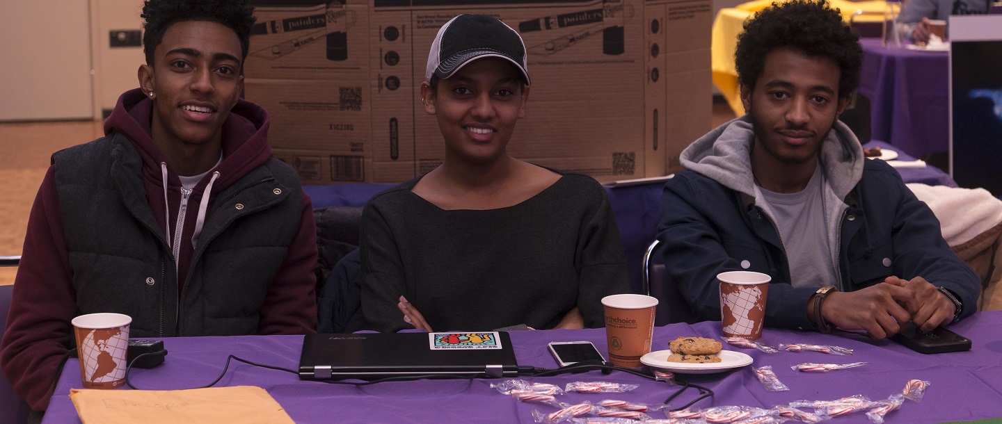 Picture of three students (two men, one woman) at a table for a resource fair