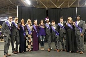 Members of the Homecoming Royalty Court of 2018 posing for a photo in a room on campus wearing purple sashes