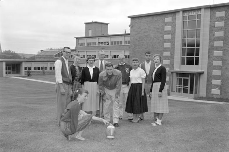 a group of people standing in a field with a football
