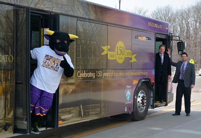 University President Richard Davenport, 2016-17 Student Association President Faical Rayani, and Stomper checked out a replacement bus wrap
