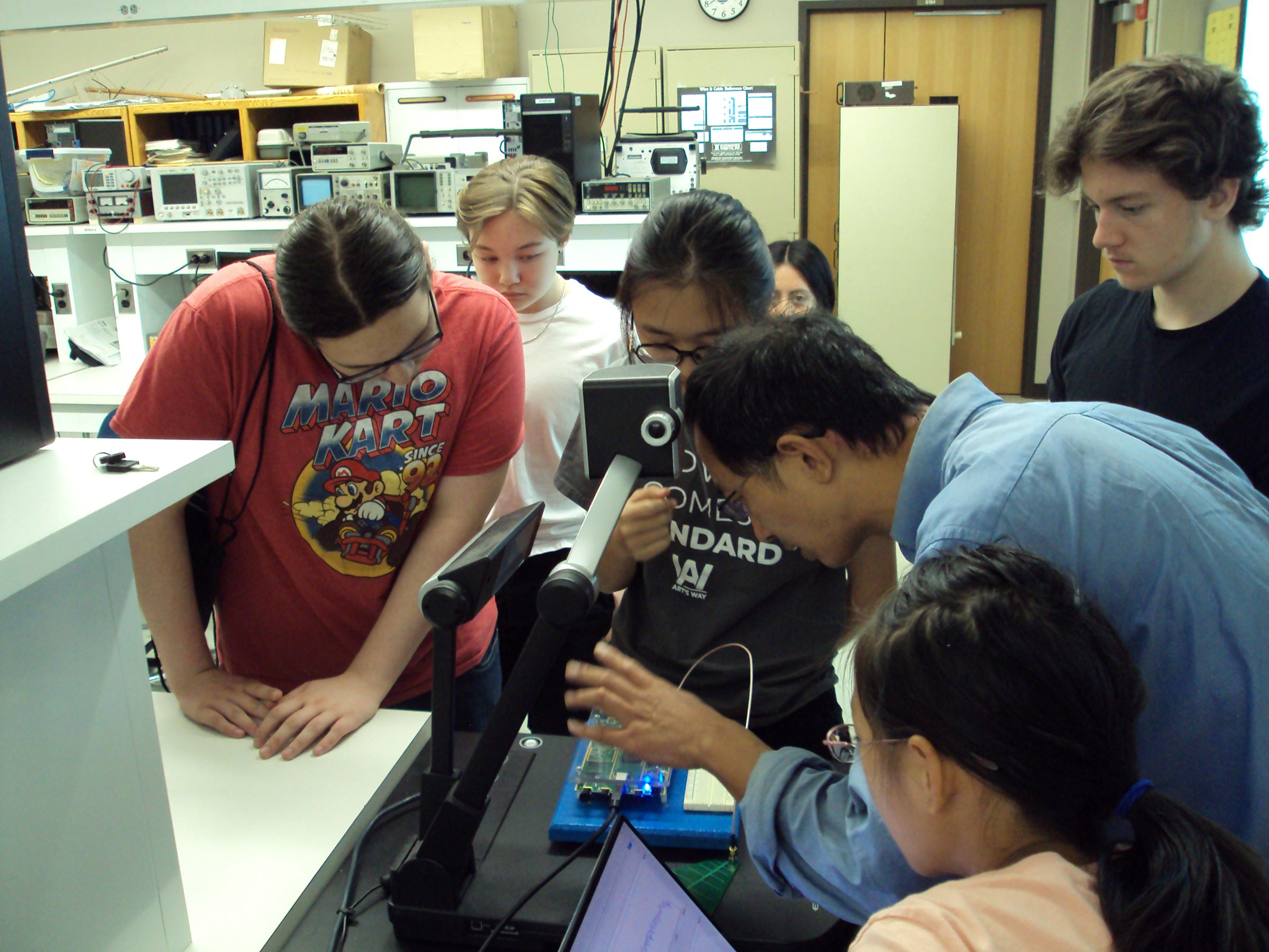 a group of people looking at a microscope