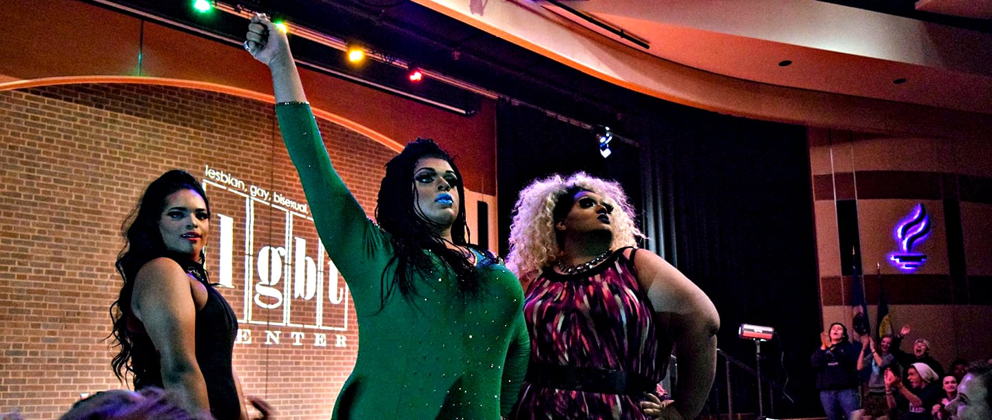 three drag queen students on stage during a drag show