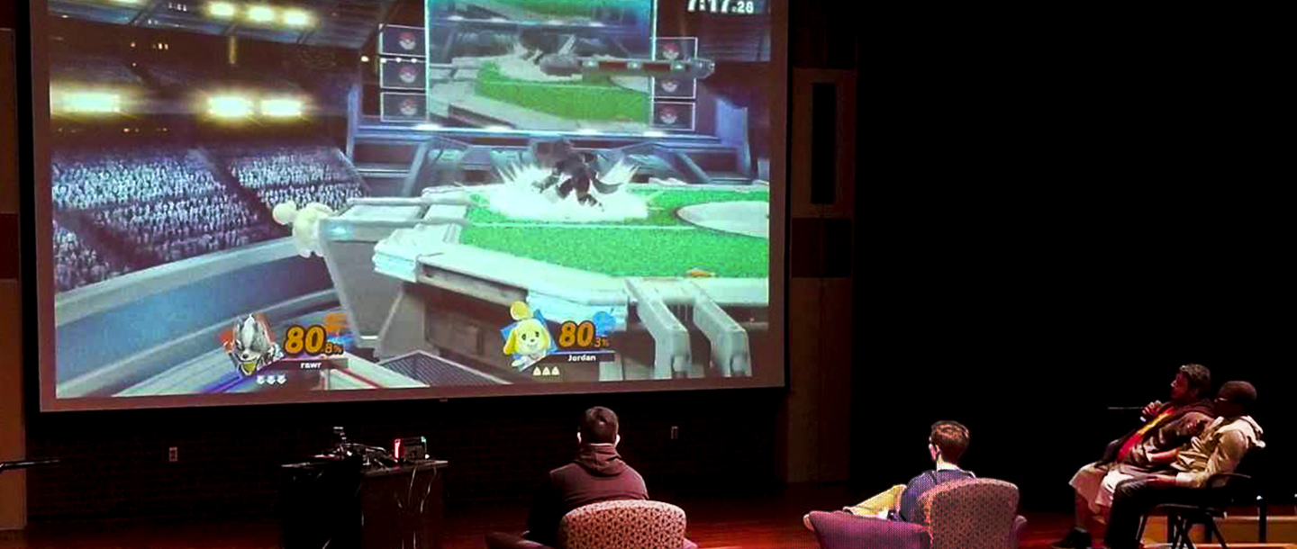 Students playing a video game in front of a huge screen