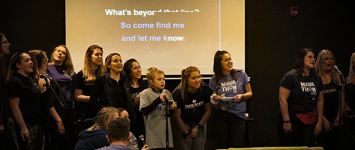 A group of female students on stage singing at the Mavathon Karaoke event
