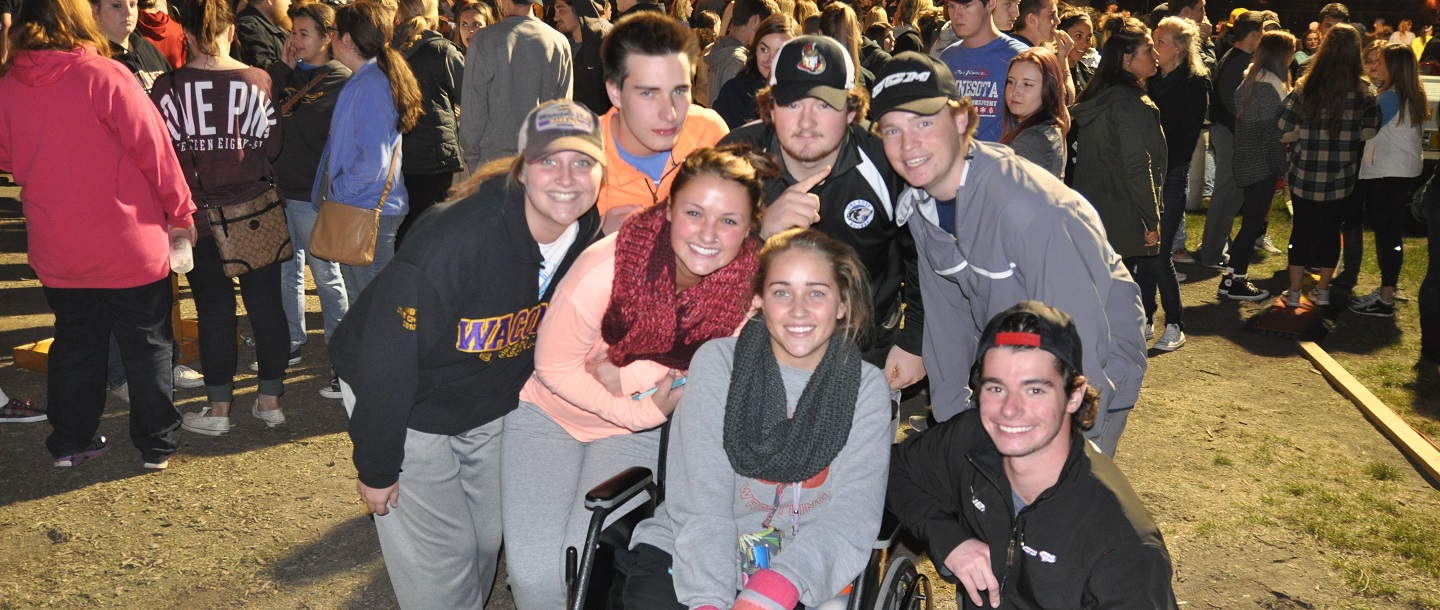 students taking group picture with a girl on the wheelchair