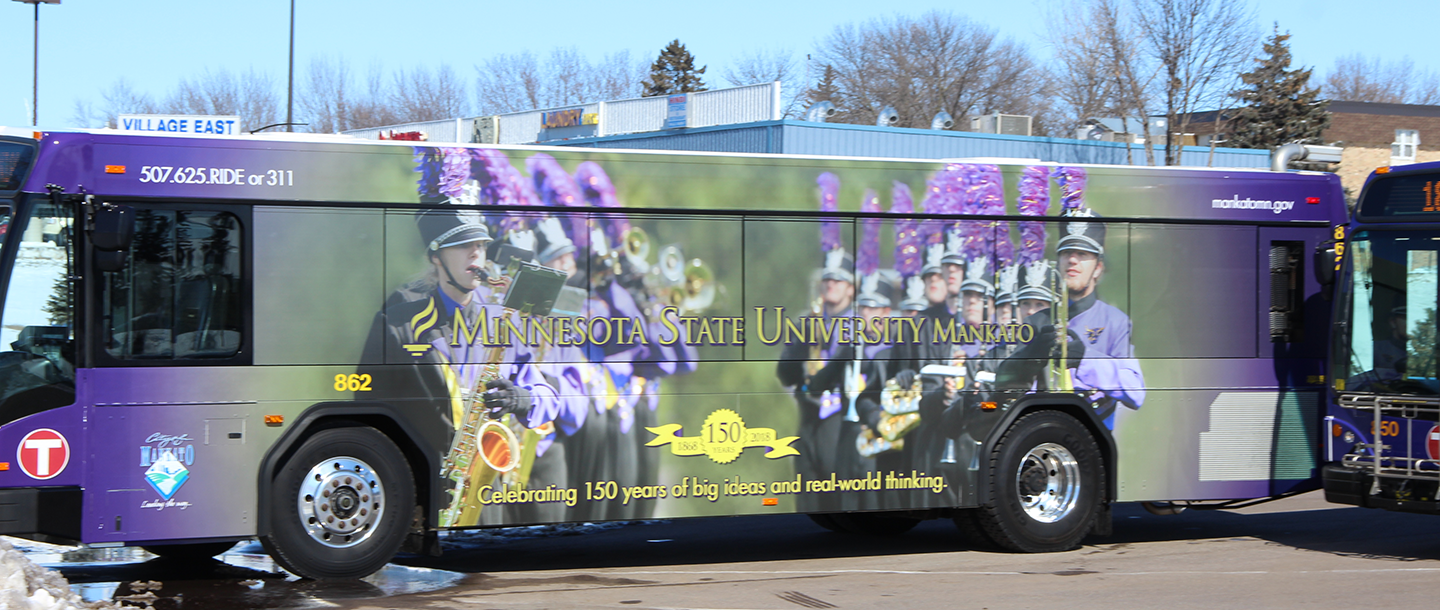 City of Mankato bus with the Minnesota State Mankato 150th anniversary logo wrap and the Maverick Machine Athletic Bands