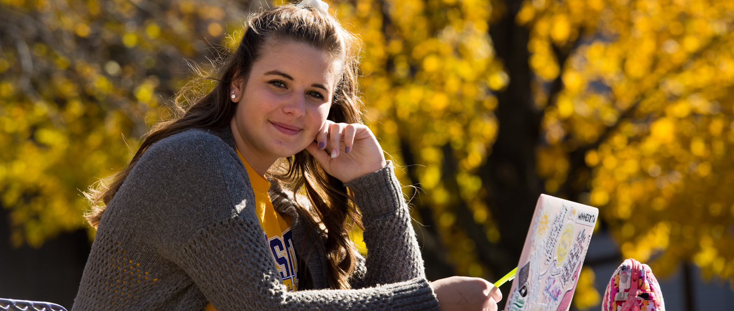 Undergraduate student on campus studying outside