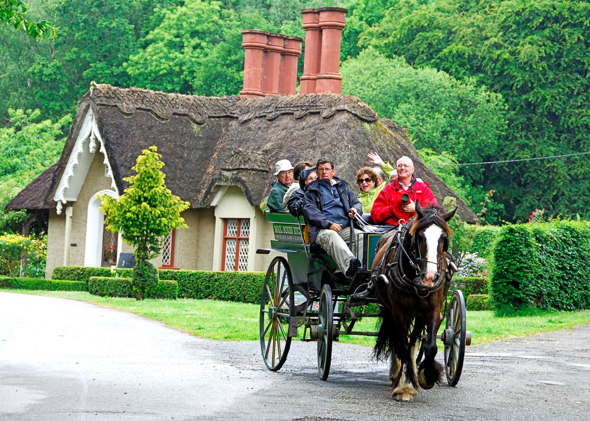 Group of people riding in a horse drawn carriage.