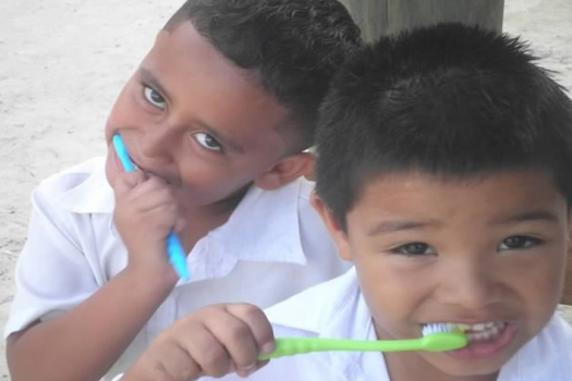 a couple of young childs brushing their teeth