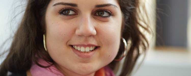 A young woman smiles into the distance. 