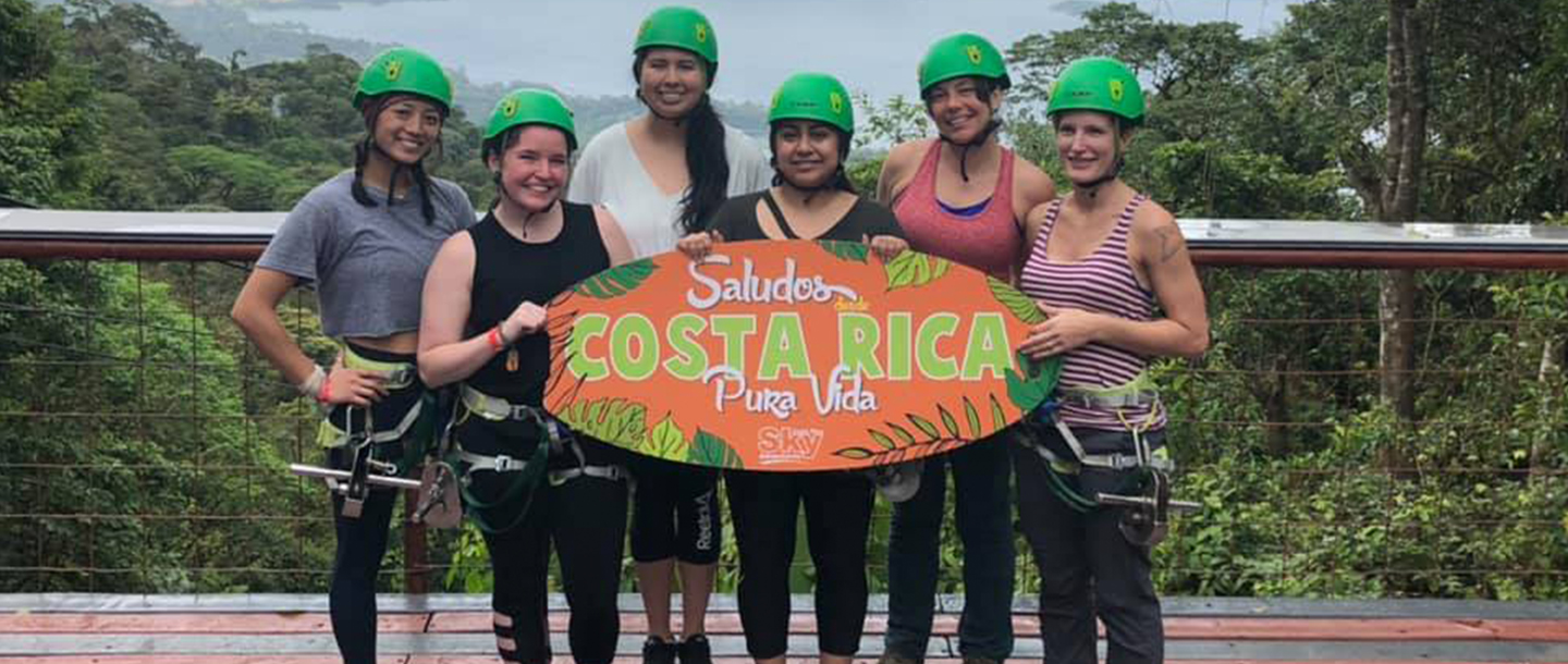 a group of women wearing green helmets holding a sign