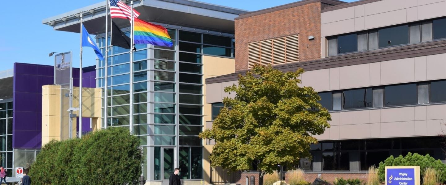 Four flags outside of the Centennial Student Union including the LGBT flag