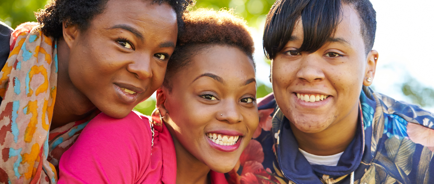 Three racially diverse girls smiling 