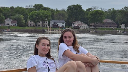 Two girls sitting on a tour boat posing