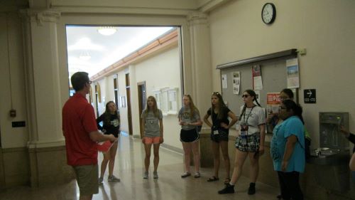 Seven girls listening to a male volunteer tour guide during their tour at St Marys