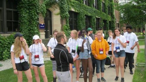 A group of the College Tour Mania students visiting Winona State University outside of Someson Hall on a tour