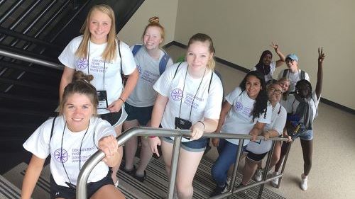 College Tour Mania students posing for a picture in a stairwell at the Winona State University campus