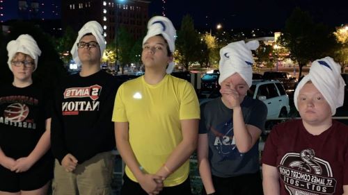 ETS students posing for a picture with bath towels on their head.