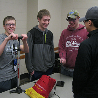 ETS students using an air pump for an experiment while visiting the U of M campus