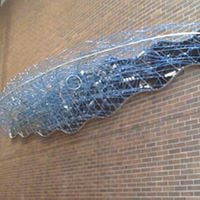 The Gravity Wave sculpture is a warp in the fabric of space-time that appears to deform and dematerialize the brick wall of the Ford Hall