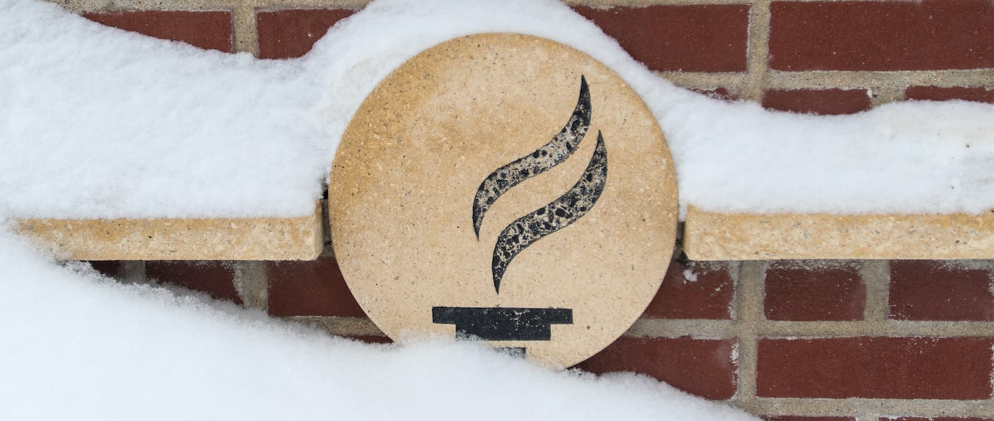 a circular stone with a logo on it in the snow