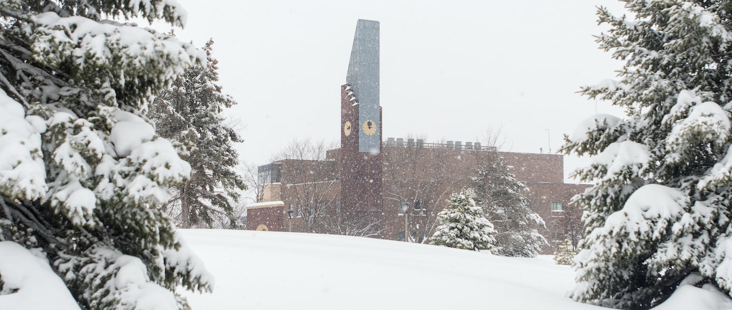 a building with a tall tower and trees in the snow