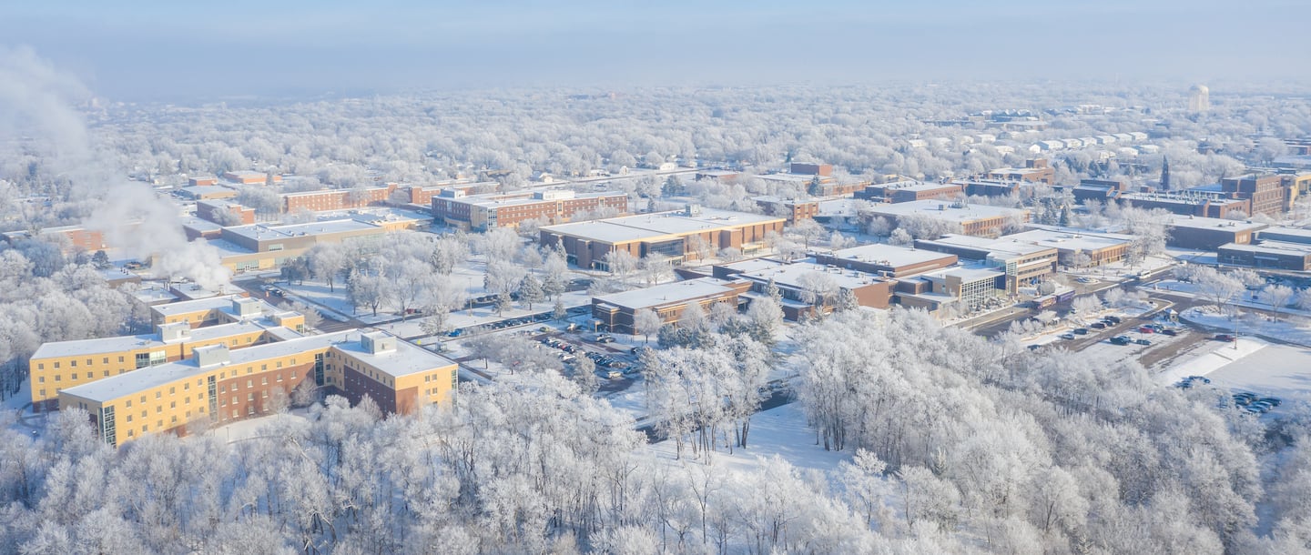 An Ariel view of the Minnesota State University, Mankato campus in winter with trees and buildings covered in snow