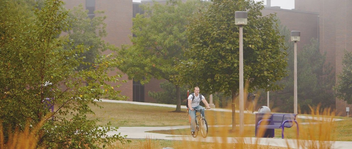 A boy bicycling by the Trafton science center area