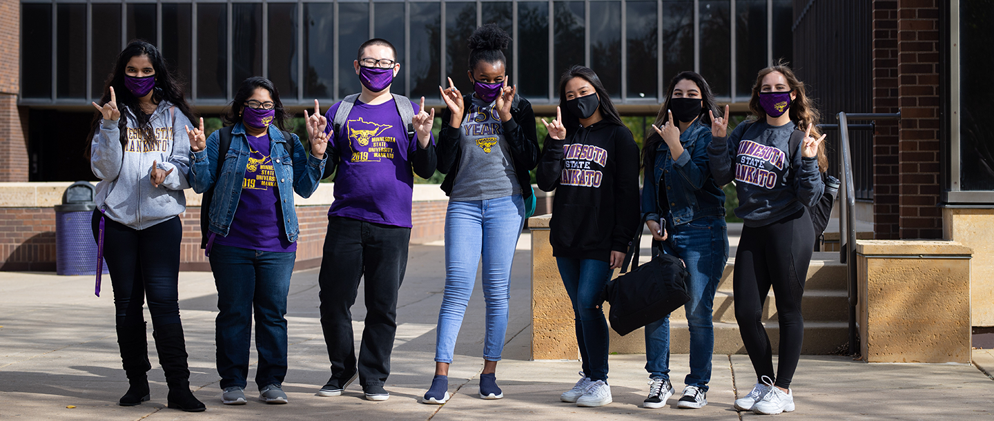 International students standing outside with Maverick masks