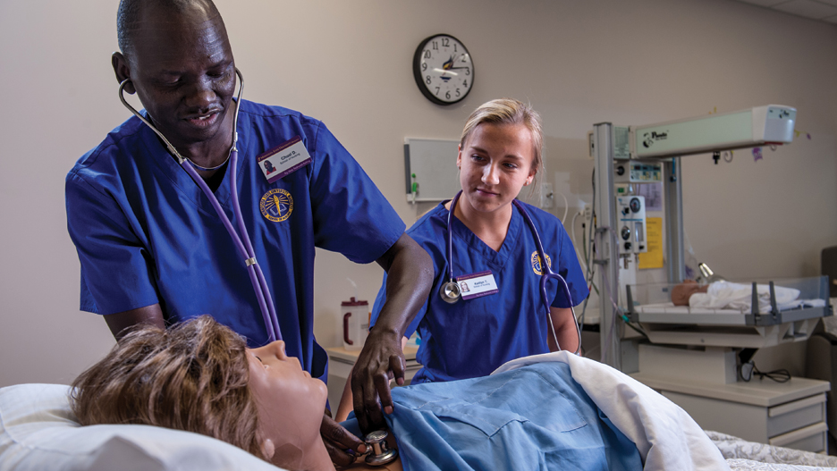 Two students perform a nursing simulation