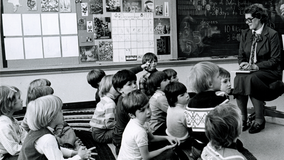 a group of children sitting on the floor in a classroom