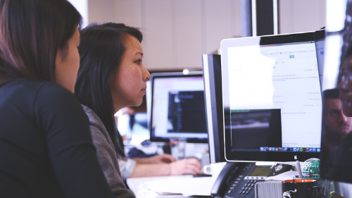 Students sitting down collaborating in the computer lab